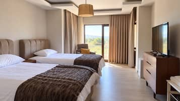 A hotel room with two beds, a television, a dresser, and a view of the outdoors.