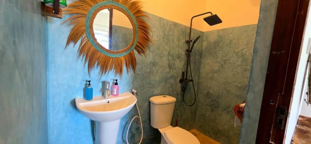Une salle de bain avec un lavabo, des toilettes et une douche.