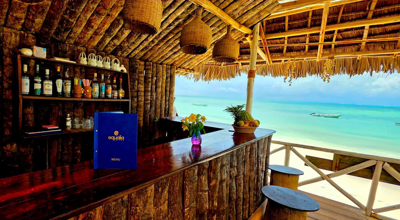 Un bar con interior de madera y vista al océano.