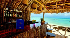 Un bar con interior de madera y vista al océano.