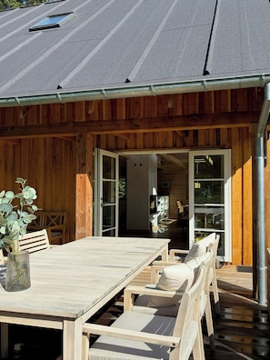 Eine Holzhütte mit Essbereich, einer Bank und einem Tisch.