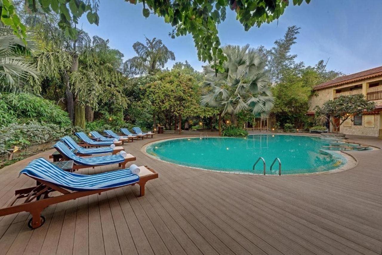 A pool area with lounge chairs and a wooden deck.