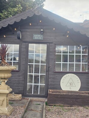 Ein Holzgebäude mit einem Schild, auf dem 'KIEBRA HOUSE' steht, und einem weiteren Schild für 'KIEBRA COFFEE & CAFE'.