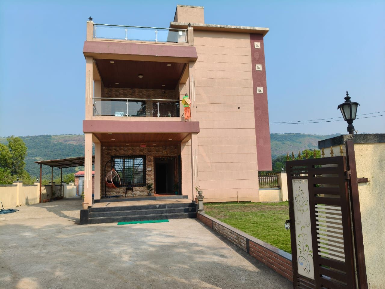 A two-story building with a balcony, a gate, and a view of the landscape.