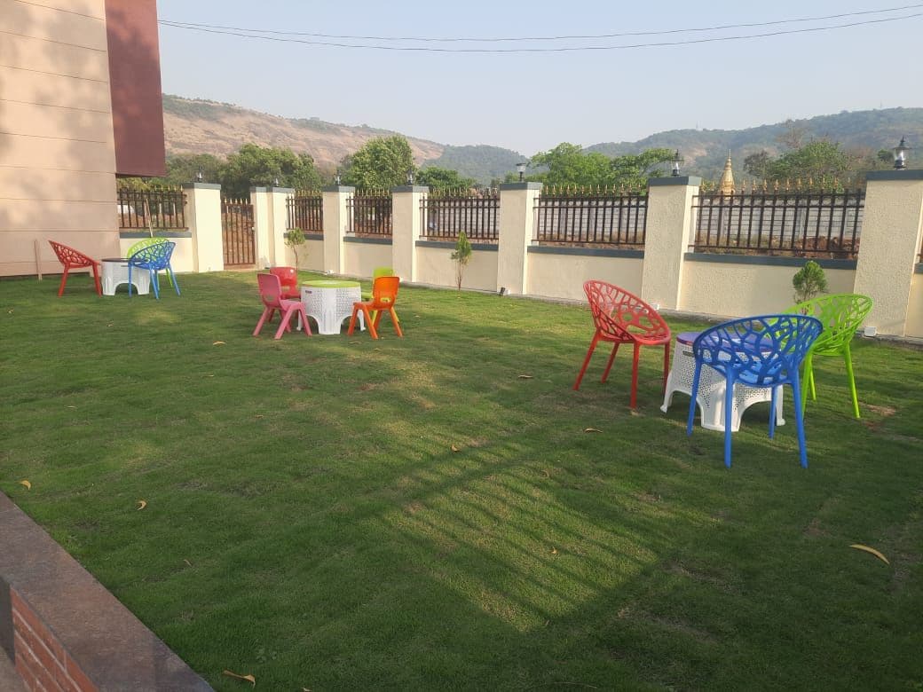 A well-maintained lawn with outdoor seating and a view of a hill.