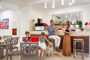 A bar area with a counter, chairs, and a dog. - Reyt (Rimini)