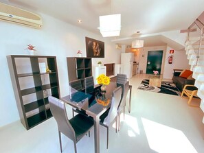 Ein modernes Wohnzimmer mit Essbereich, Treppe und Küche.
