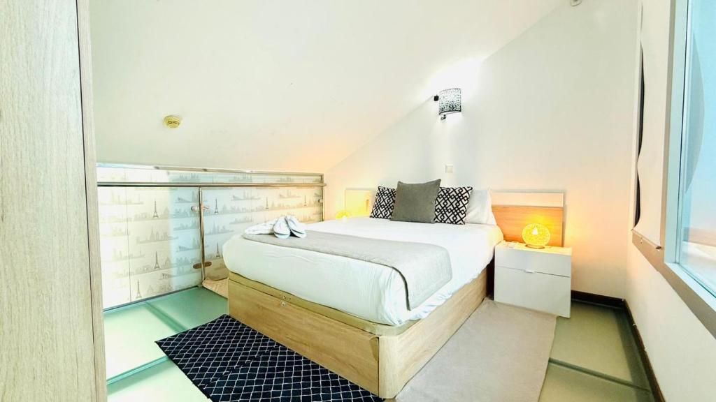 A bedroom with a bed, bedside tables, a nightstand, and a window.