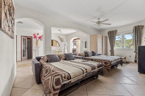 A bedroom with two beds, a ceiling fan, and a window with curtains. - La Treille de Saint-Marc by sur la mer (Camps-la-Source)