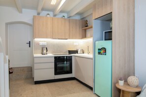 A modern kitchen with wooden cabinets, a built-in oven, a sink, and a refrigerator. - Kiara Garitsa House - Beautiful 1-bedroom apartment with AC in Corfu Town (Corfu Town)