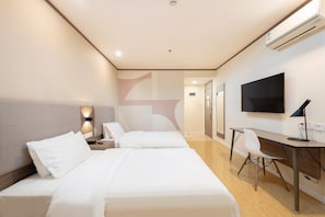 A hotel room with two beds, a desk, a chair, a TV, and an air conditioning unit. - Hanting Hotel Shanghai (Shanghai)