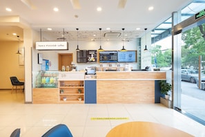A modern coffee shop interior with a wooden counter, menu boards, and a glass display case. - Hanting Hotel Shanghai (Shanghai)