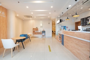 A modern cafe interior with wooden accents, a counter, and seating area. - Hanting Hotel Shanghai (Shanghai)