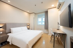 A hotel room with a bed, bedside table, lamp, desk, chair, and a TV. - Hanting Hotel Shanghai (Shanghai)