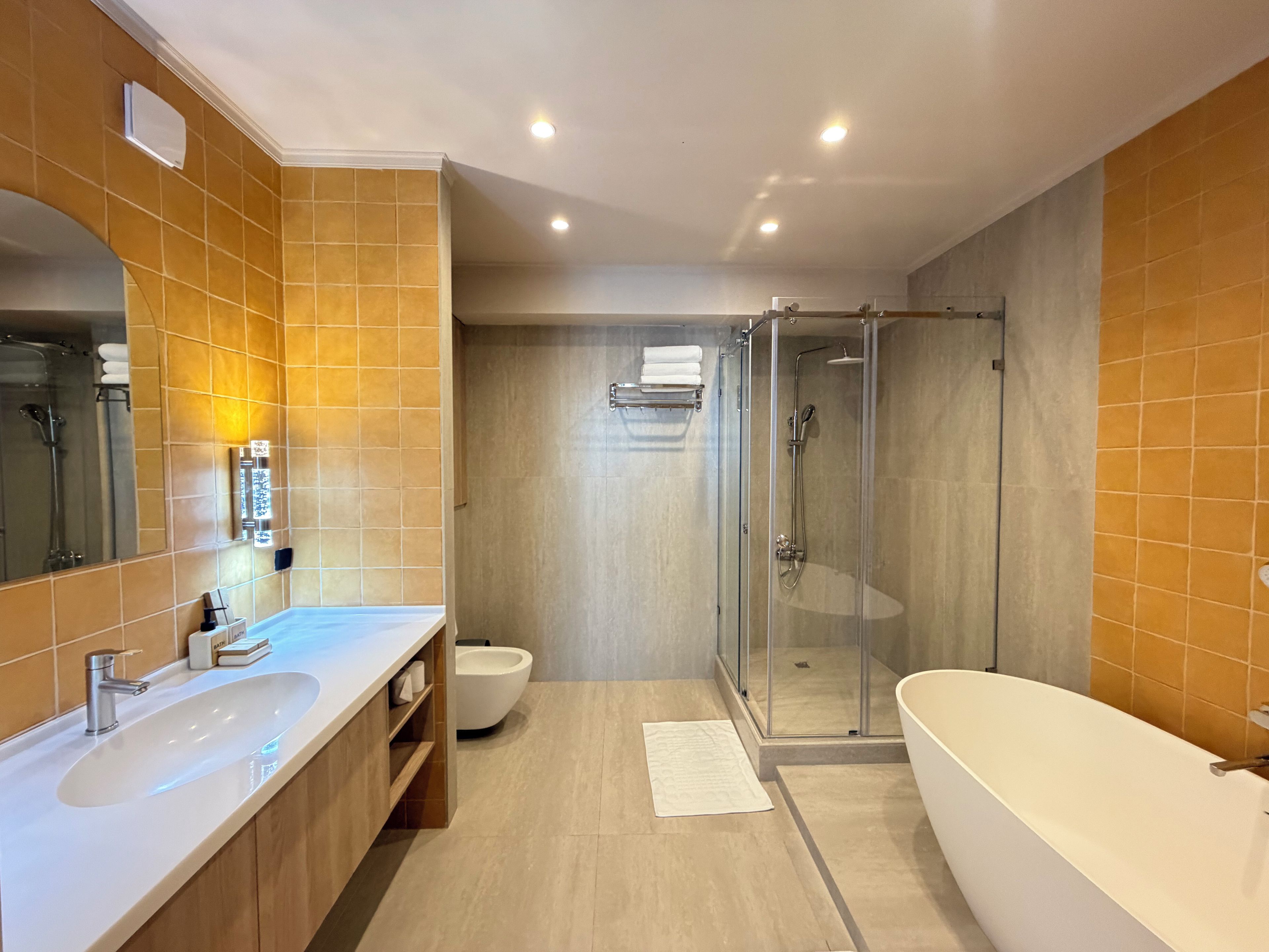 Ein modernes Badezimmer mit einer großen Badewanne, einer Duschkabine und einem Doppelwaschtisch.