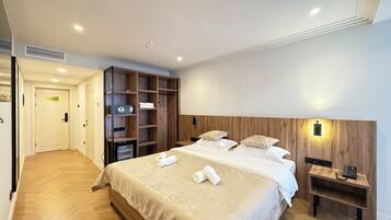 Una habitación de hotel con cama, mesitas de noche, armario y vestidor.