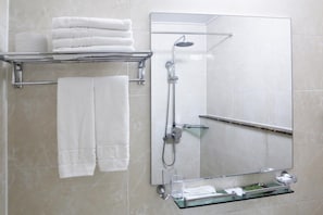 A bathroom with a glass shower enclosure, a towel rack with folded towels, and a glass shelf with toiletries. - The Hotel Yeongjong Incheon Airport (Incheon)