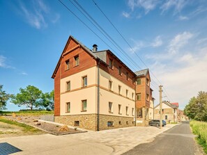 Ein mehrstöckiges Wohngebäude mit Steinverkleidung und einem geneigten Dach.