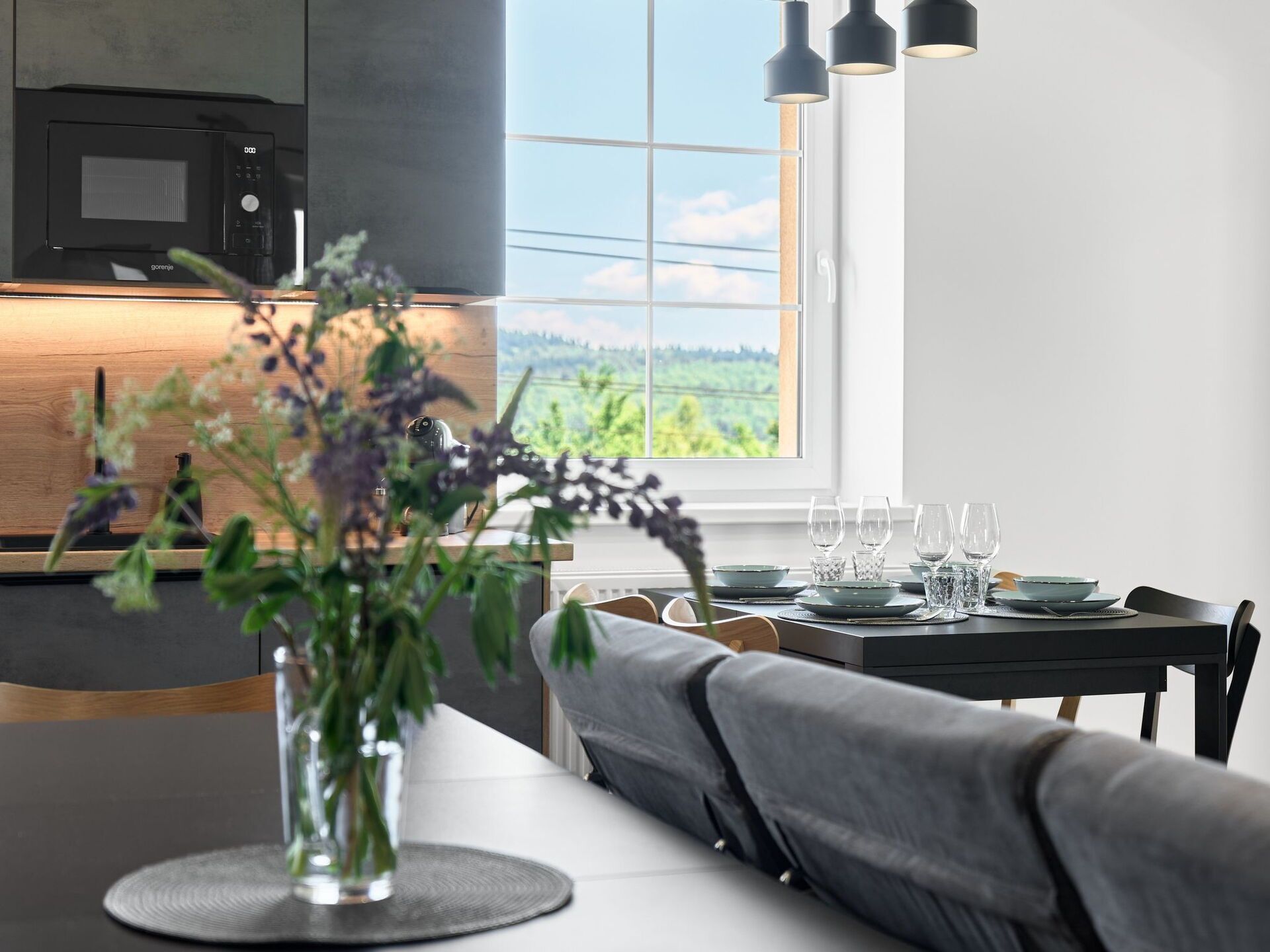 Una cocina moderna con horno integrado y comedor con vistas al exterior.