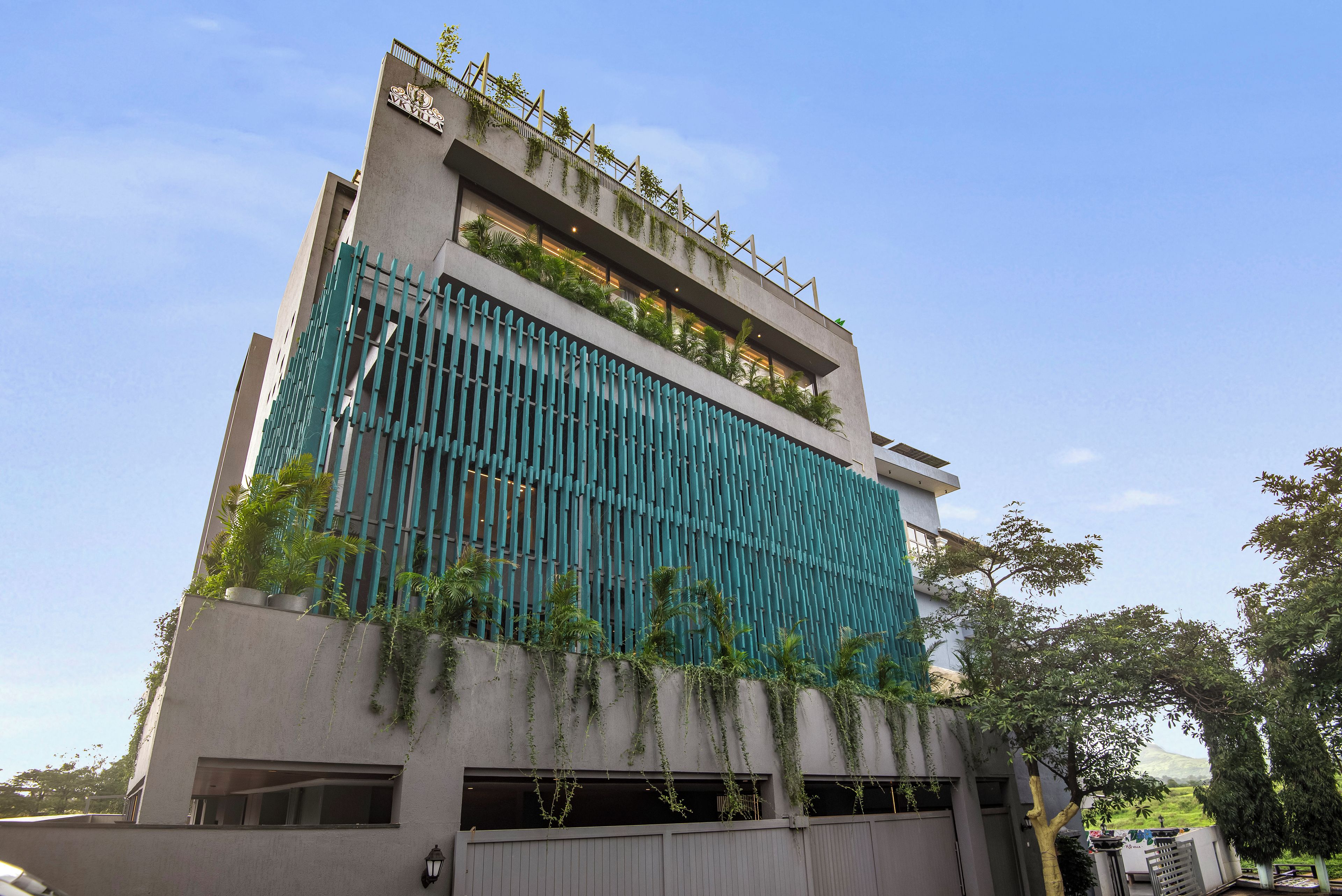 A modern building with a vertical garden, large windows, and a gated entrance.