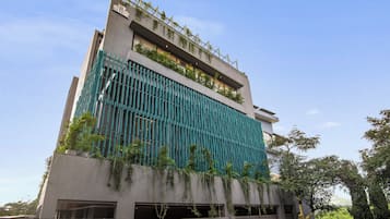 A modern building with a vertical garden, large windows, and a gated entrance.