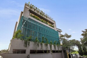 A modern building with a vertical garden, large windows, and a gated entrance.