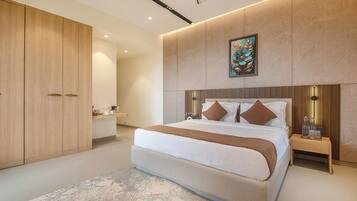 A modern bedroom with a large bed, a wardrobe, bedside tables, and a painting on the wall.