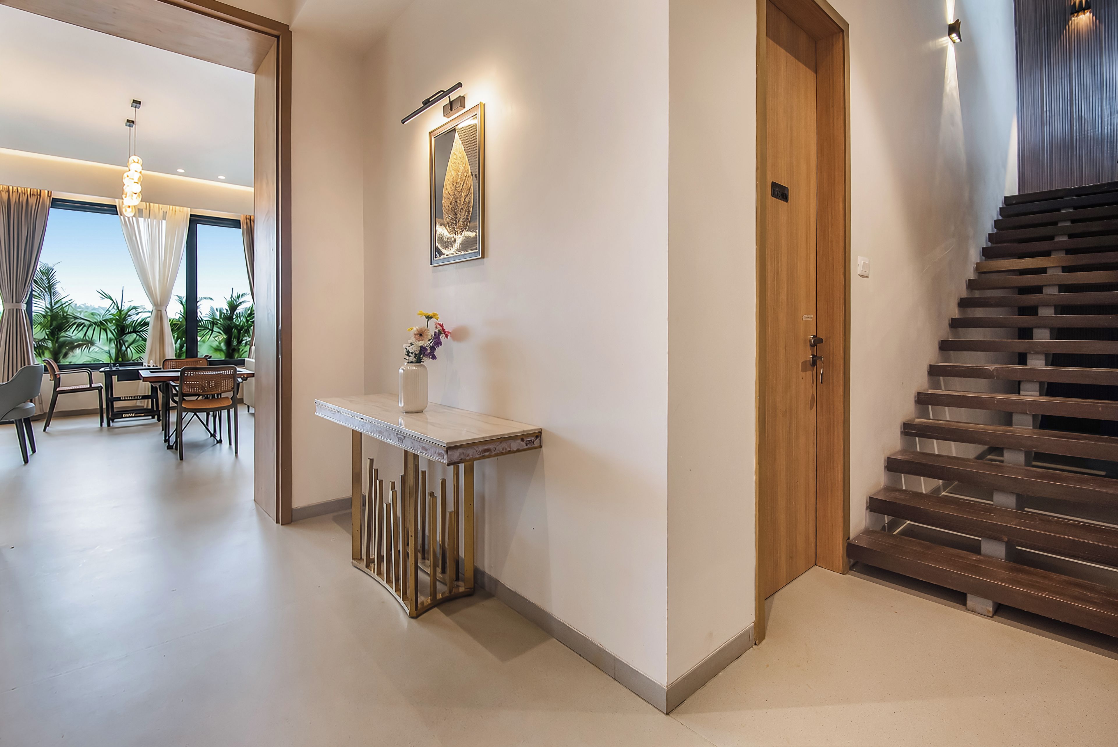 Ein modernes Interieur mit Essbereich, einer Treppe und einem zur Küche führenden Flur.