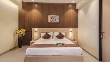 A modern hotel room with a large bed, wooden panel wall, and a decorative painting.