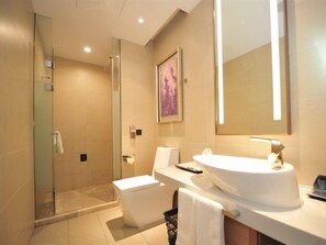 A modern bathroom with a glass-enclosed shower, a white sink, and a large mirror. - Lavande Hotels (Harbin)
