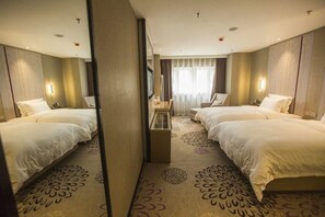 A hotel room with two beds, a mirror, a small table, and a window with curtains. - Lavande Hotels (Harbin)