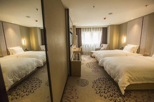 A hotel room with two beds, a mirror, a small table, and a window with curtains. - Lavande Hotels (Harbin)