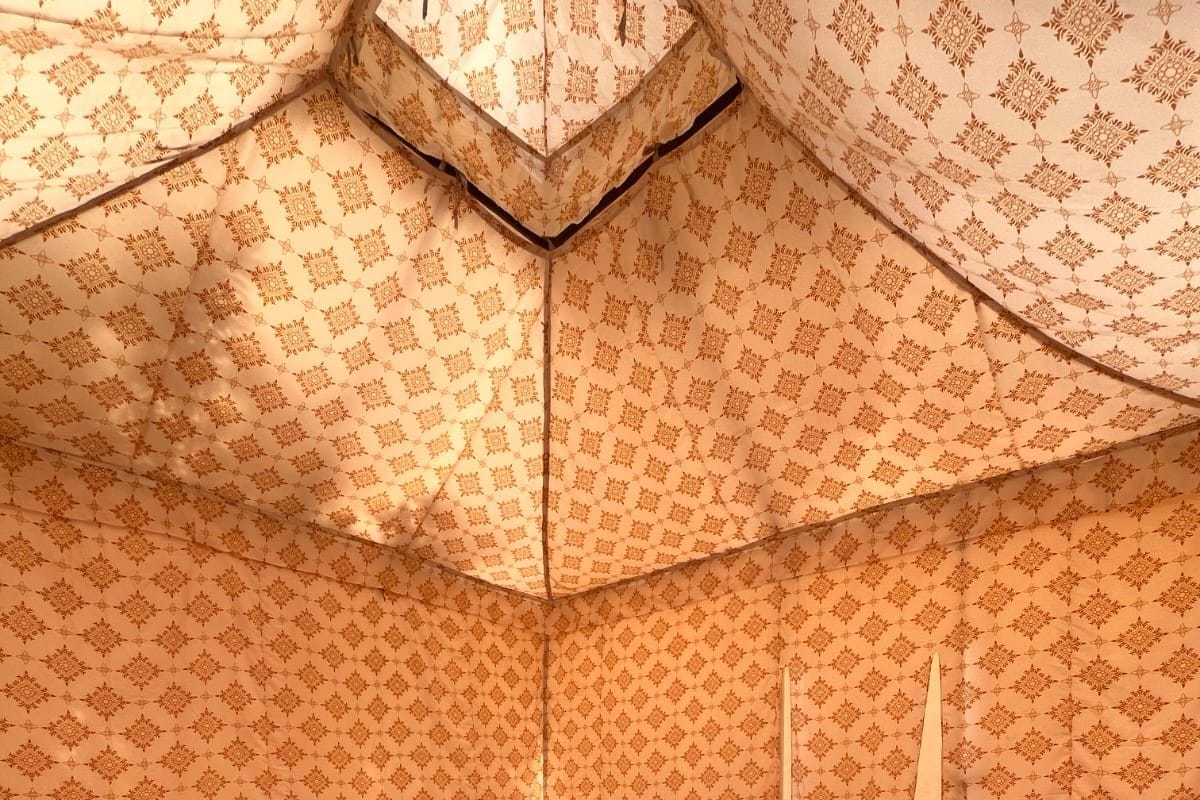 Una habitació amb un llit, una taula de vidre i una cadira.