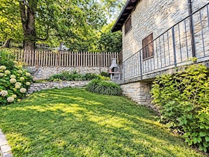 Ein Steinhaus mit einer Steinmauer und einem Holzzaun.