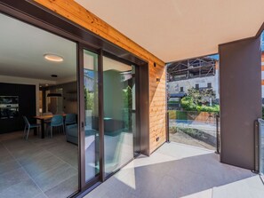 Ein modernes Interieur mit Essbereich, Küche und einer Glastür zum Außenbereich.