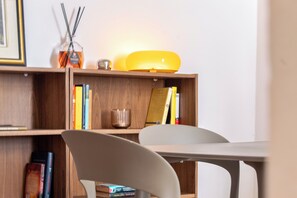 A room with a wooden bookshelf, a white table, and a chair. - Charming 2-bedroom apartment in the heart of the historic center (Cagliari)