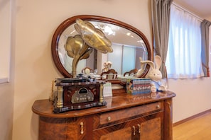 A wooden dresser with a vintage radio, a decorative lamp, and a calendar. - Rabbit house (Edogawaku)