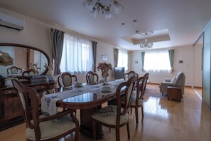 A dining room with a wooden table set for four, surrounded by chairs. - Rabbit house (Edogawaku)