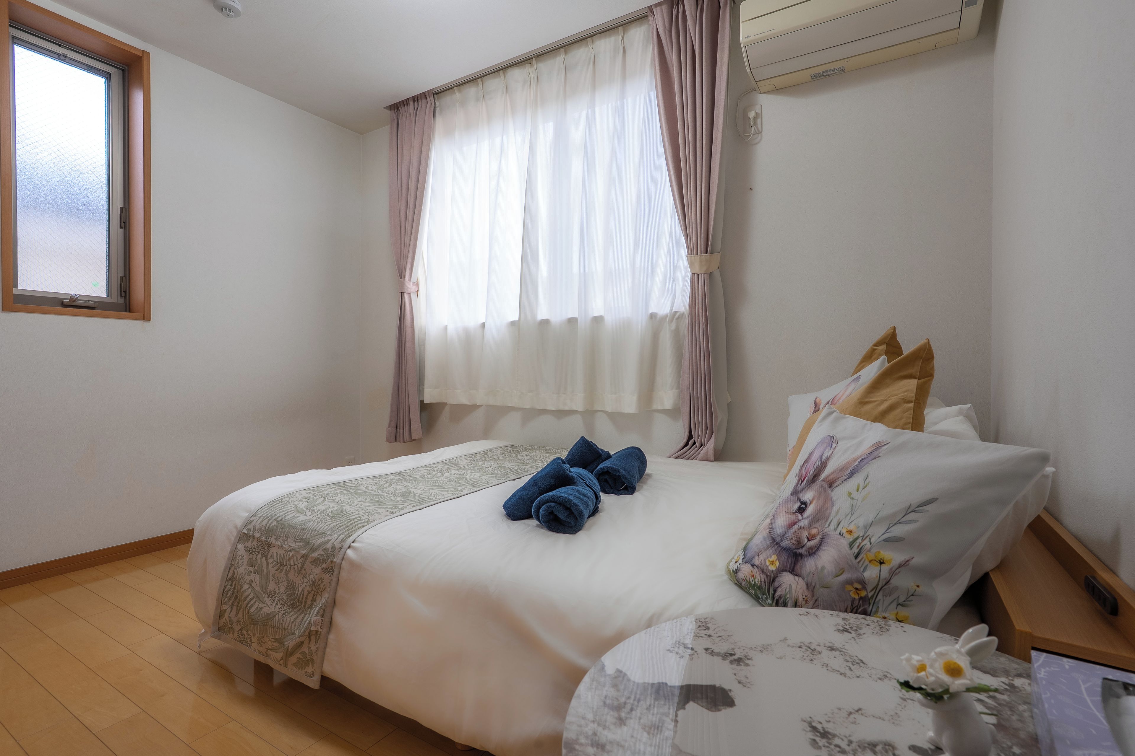A bedroom with a bed, a window, and a curtain.