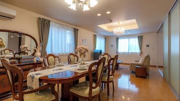 A dining area with a wooden table, chairs, and a chandelier.