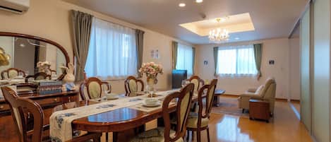 A dining area with a wooden table, chairs, and a chandelier.