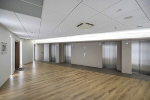 A spacious hallway with a wooden floor, multiple doors, and a ceiling with recessed lighting and ventilation. - Wroclaw | Gwiaździsta 64 | Apartment with a View | Parking (Wrocław)