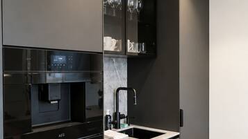 Una cocina moderna con electrodomésticos integrados, un fregadero y un piso de madera en espiga.