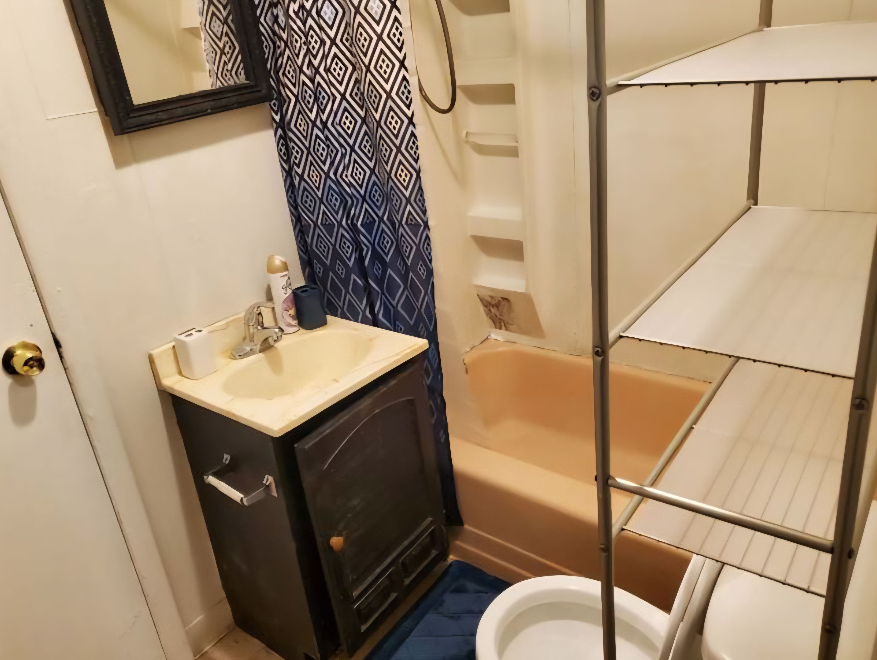 A bathroom with a sink, mirror, toilet, and bathtub.