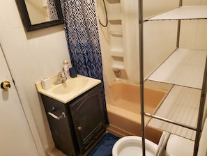 Un baño con lavamanos, espejo, inodoro y bañera.