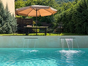 Refreshing shared pool with waterfall features and a tranquil garden backdrop. - Anerada Inn Suites Pool & Spa | Lilac Suite (Megalo chorio)