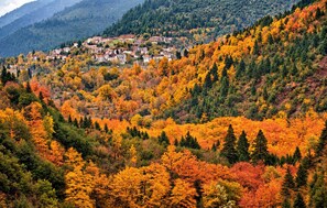 Eine gebirgige Landschaft mit einer Ansammlung von Gebäuden an einem Hang.