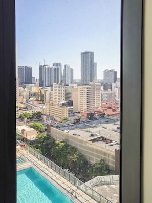 A cityscape with high-rise buildings, a swimming pool, and a fenced area. - Luxury Apartment with shared pool (Miami)