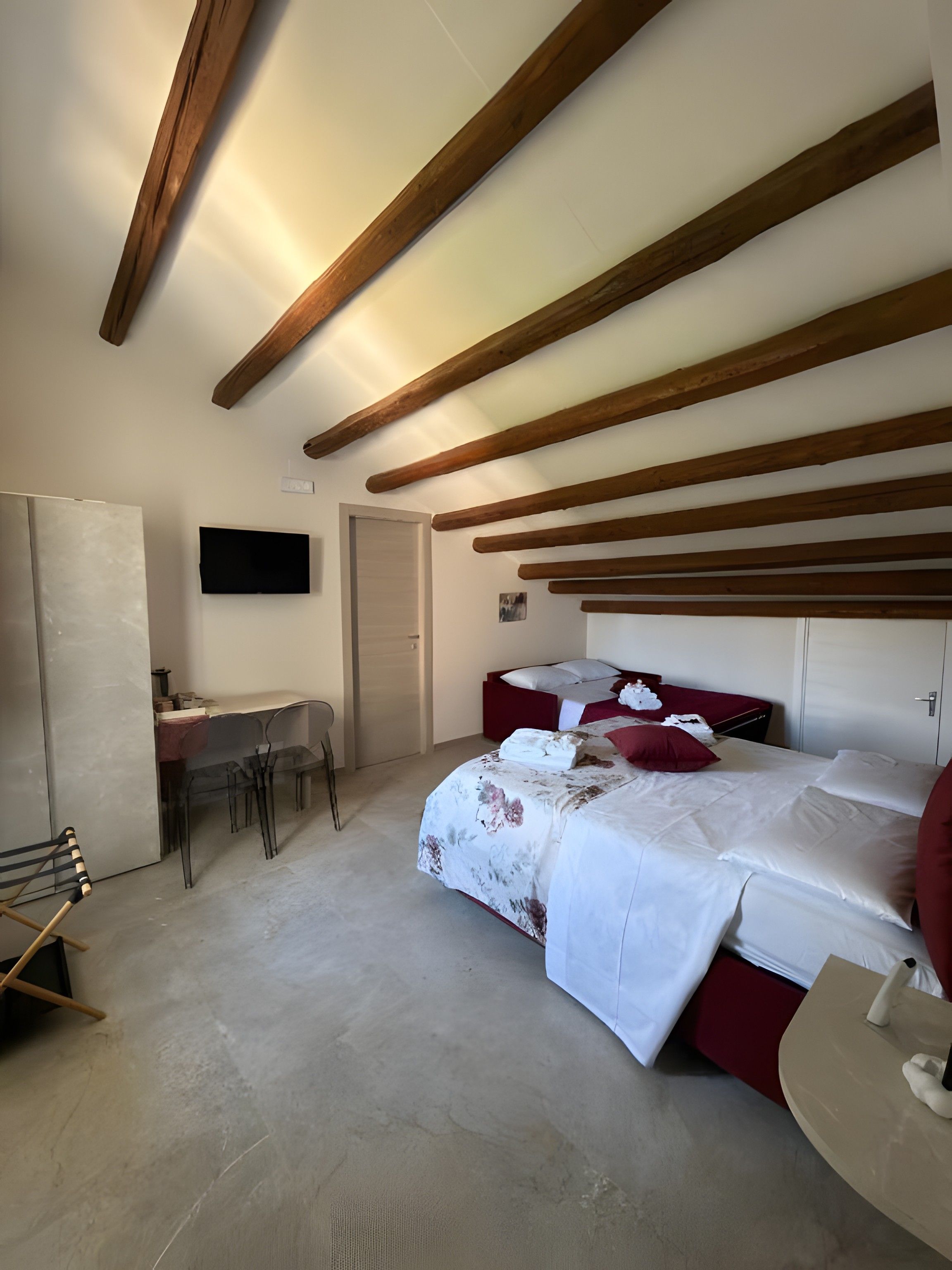 A bedroom with a bed, a desk, and a chair.