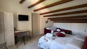 A bedroom with a bed, a desk, and a chair.